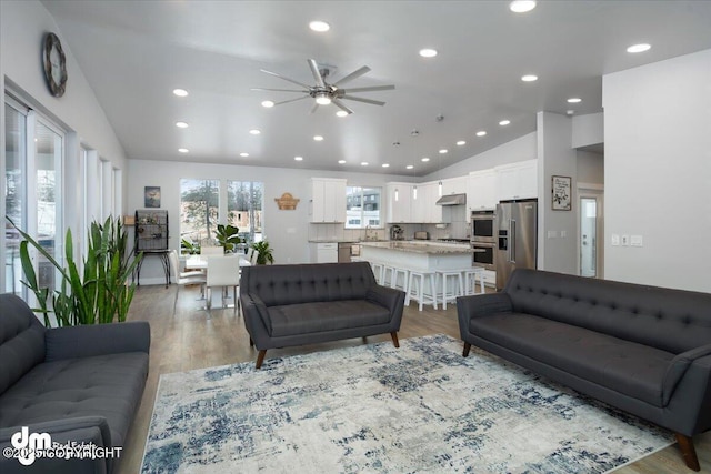 living area featuring a ceiling fan, vaulted ceiling, wood finished floors, and recessed lighting