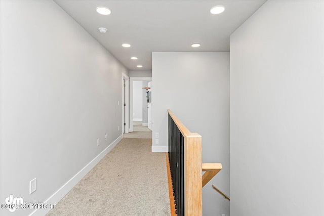 hallway featuring an upstairs landing, carpet, baseboards, and recessed lighting