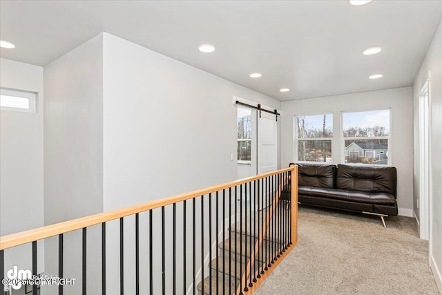 hall with carpet floors, recessed lighting, baseboards, and a barn door