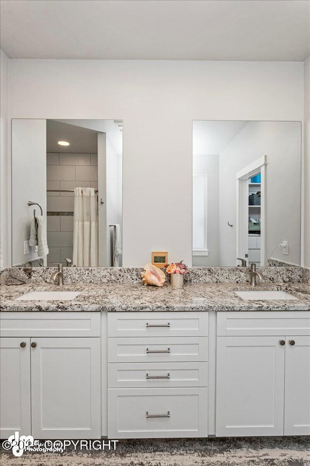 bathroom featuring a tile shower and vanity