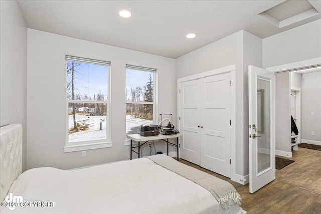 bedroom with a closet, baseboards, wood finished floors, and recessed lighting