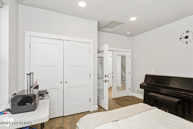 bedroom with recessed lighting, wood finished floors, visible vents, baseboards, and a closet