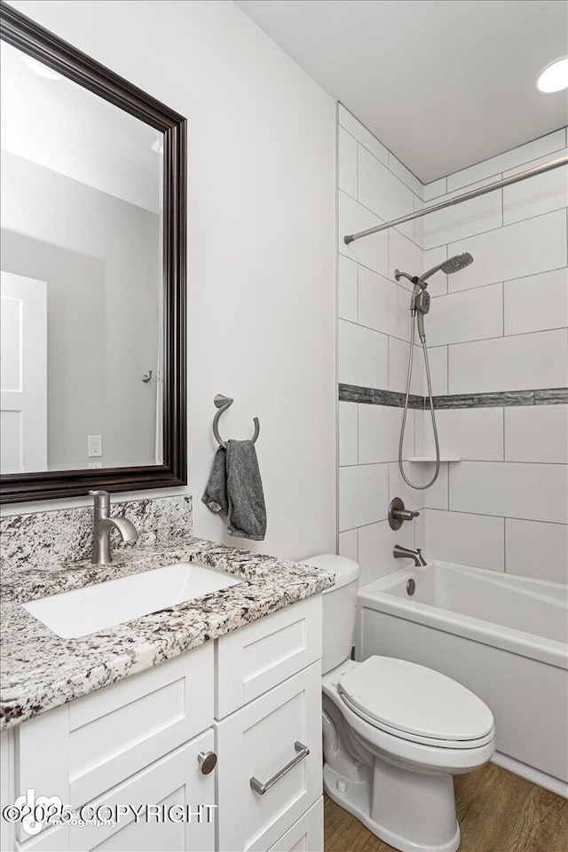 bathroom with toilet, bathtub / shower combination, wood finished floors, and vanity