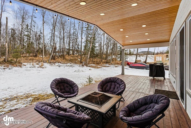 snow covered deck with a fire pit