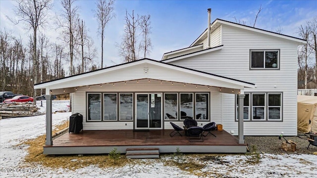 rear view of house with a wooden deck and a sunroom