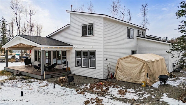 snow covered house featuring a wooden deck