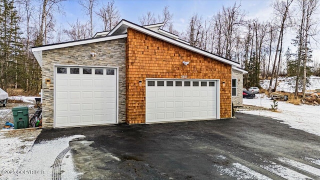 snow covered garage featuring a detached garage