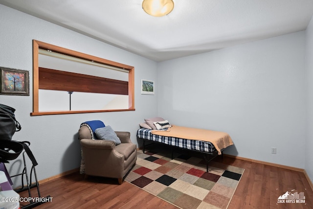 bedroom featuring baseboards and wood finished floors