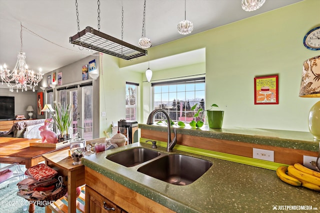 kitchen with pendant lighting, a sink, and an inviting chandelier