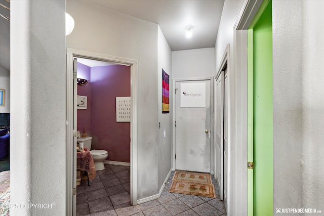 bathroom with tile patterned flooring, toilet, and baseboards