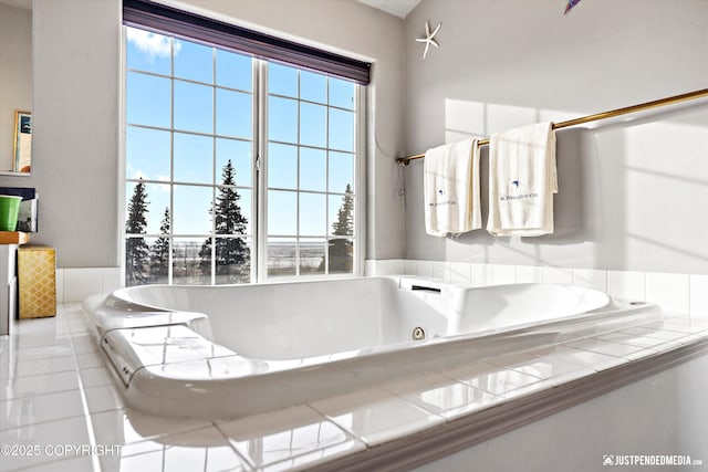 bathroom with a wealth of natural light, tile patterned flooring, and a tub with jets