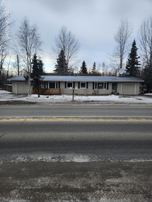 snow covered building featuring an attached garage