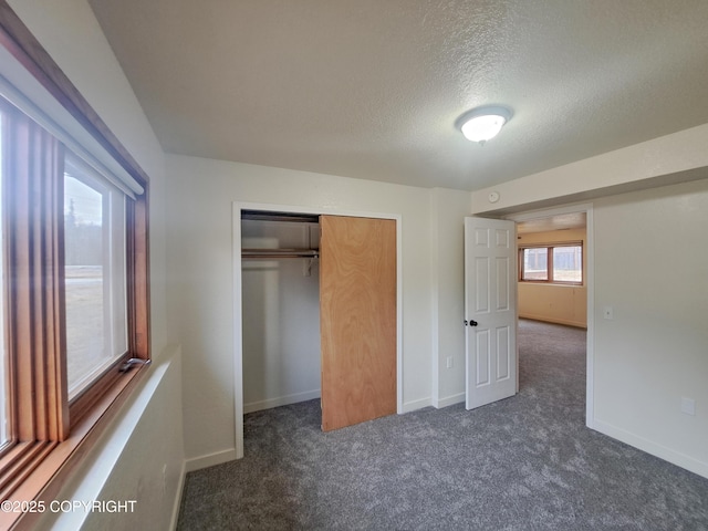 unfurnished bedroom featuring carpet, a closet, and baseboards