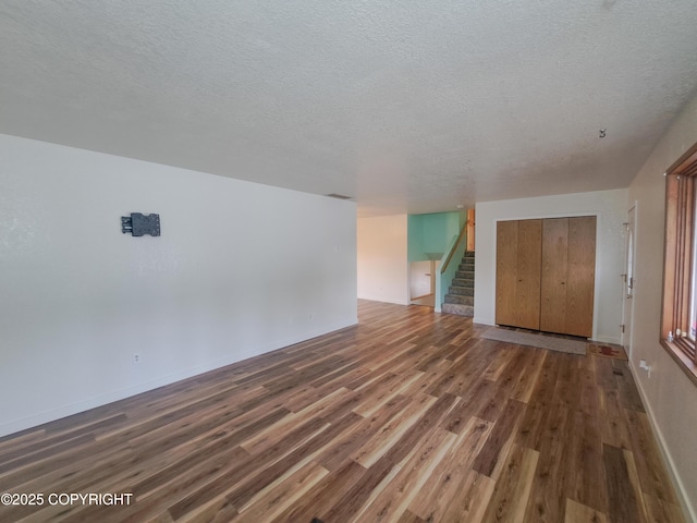 interior space with stairway, a textured ceiling, and wood finished floors