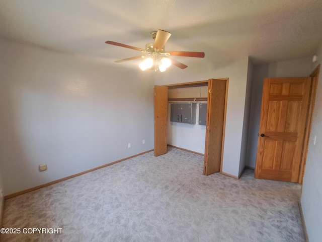 unfurnished bedroom with carpet floors, a ceiling fan, baseboards, and a closet