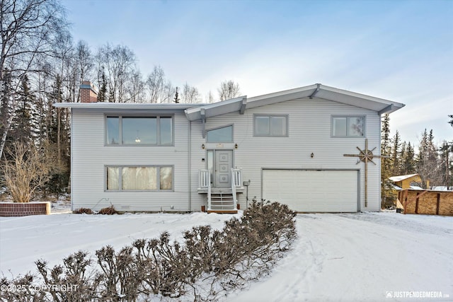 split foyer home with a chimney and an attached garage