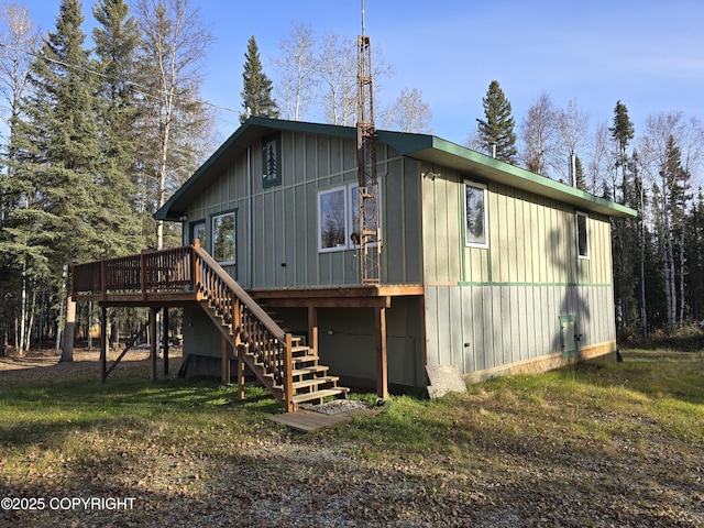 back of house with stairway, a deck, and board and batten siding