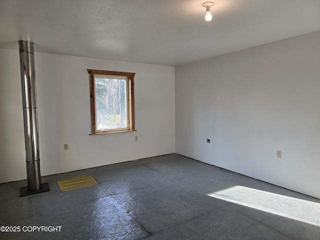 spare room featuring visible vents, concrete floors, and a textured ceiling