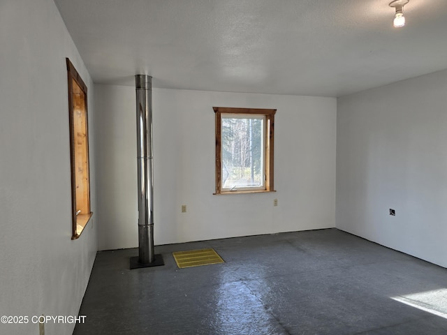 unfurnished room with concrete flooring and a textured ceiling