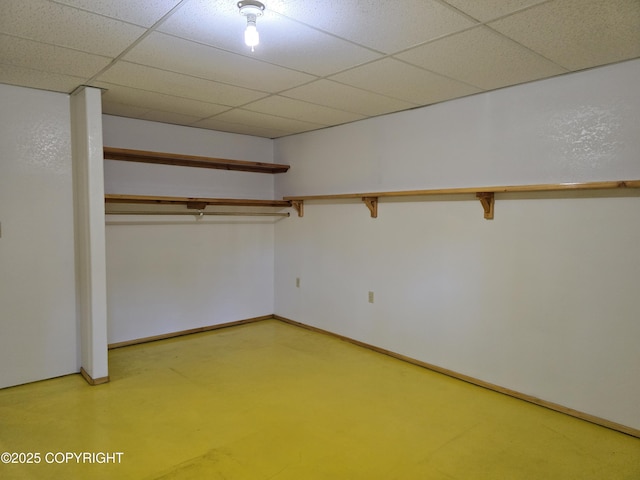 interior space with a drop ceiling and baseboards