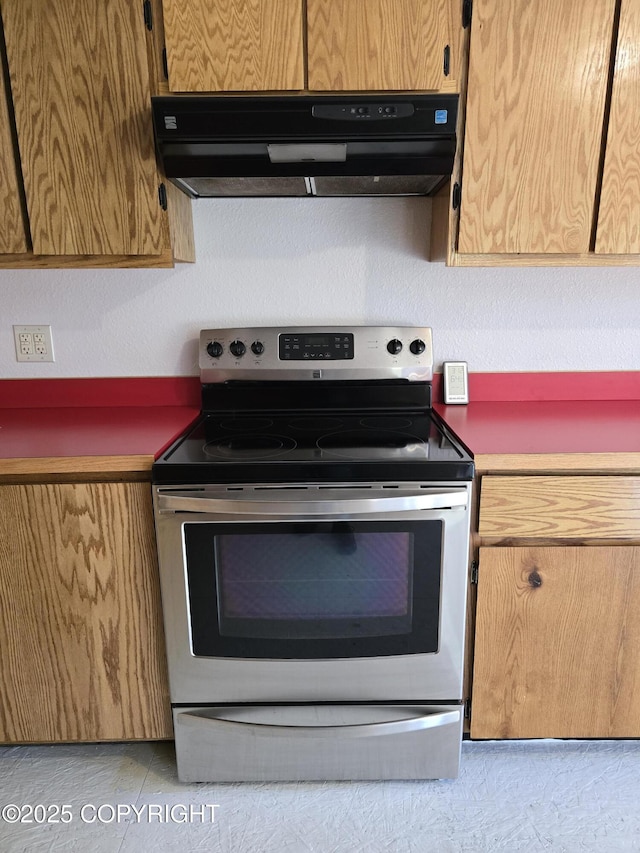 kitchen featuring electric range and ventilation hood