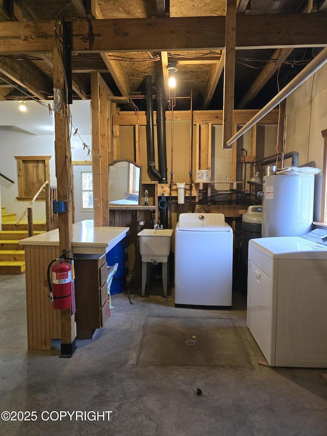 below grade area featuring separate washer and dryer, gas water heater, and a sink