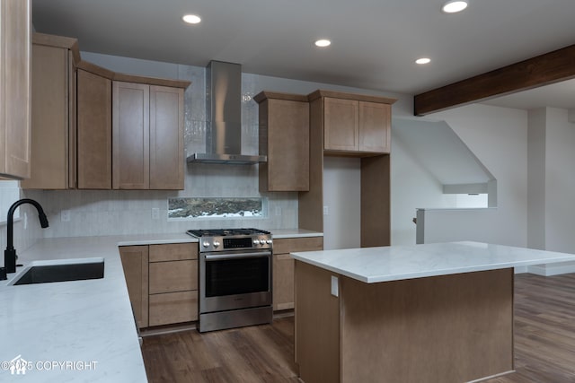 kitchen featuring wall chimney exhaust hood, stainless steel gas range oven, a sink, and dark wood finished floors