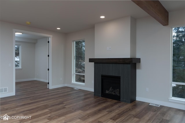 unfurnished living room featuring recessed lighting, visible vents, beamed ceiling, and wood finished floors