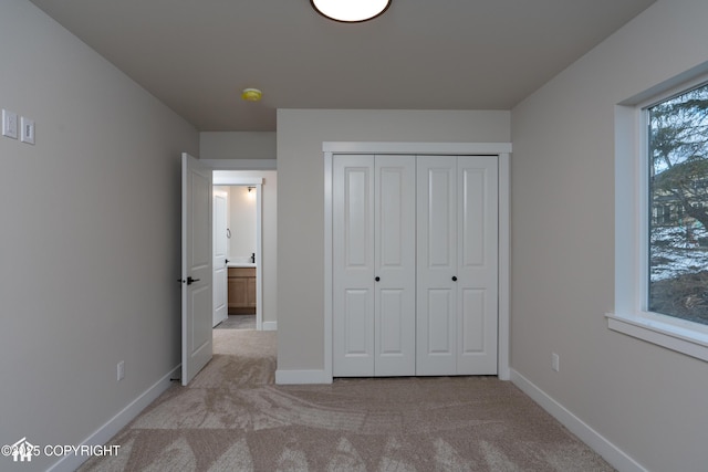 unfurnished bedroom featuring a closet, carpet flooring, and baseboards