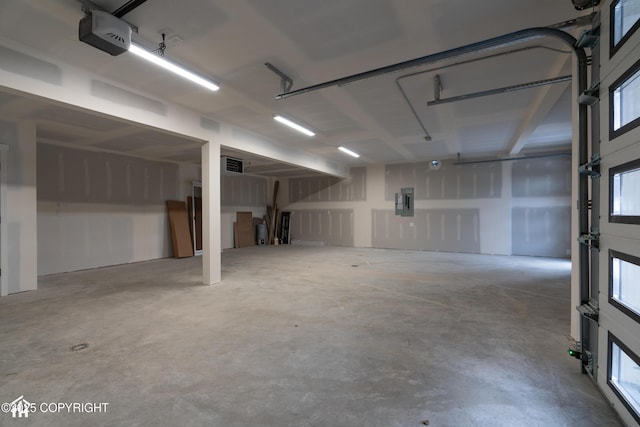 garage featuring electric panel and a garage door opener