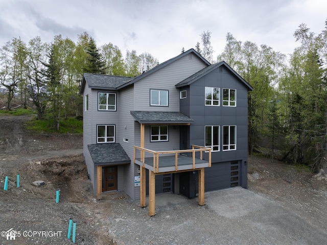 14311 Pickett St, Anchorage, AK 99516 - back of property with roof with shingles, a garage, driveway, and view of wooded area