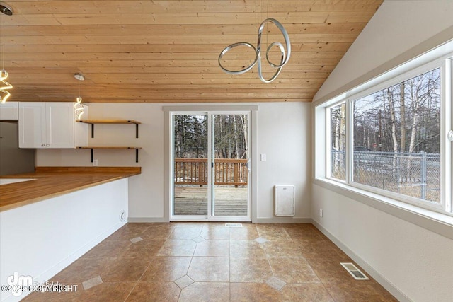 unfurnished dining area featuring tile patterned floors, visible vents, baseboards, wooden ceiling, and lofted ceiling