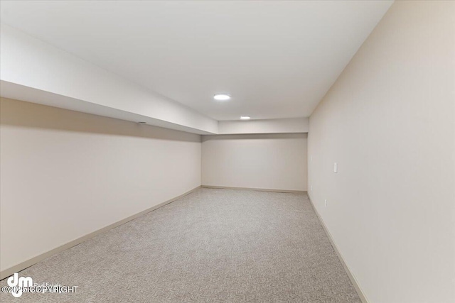 finished basement featuring light carpet and baseboards