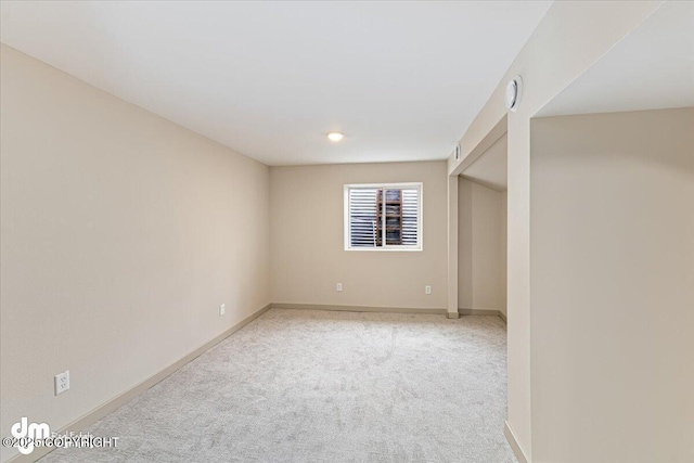 empty room with baseboards and light carpet