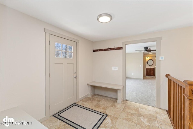 foyer featuring light colored carpet and baseboards