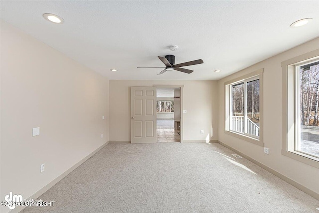 carpeted spare room featuring recessed lighting, visible vents, and baseboards