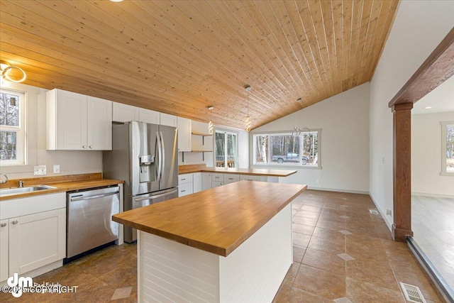 kitchen with visible vents, butcher block countertops, a sink, stainless steel appliances, and wooden ceiling