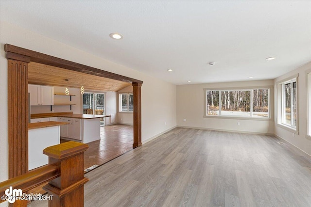 unfurnished living room with recessed lighting, baseboards, and light wood-style floors