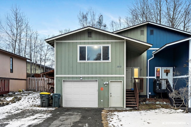 view of front of home featuring a garage, driveway, and fence