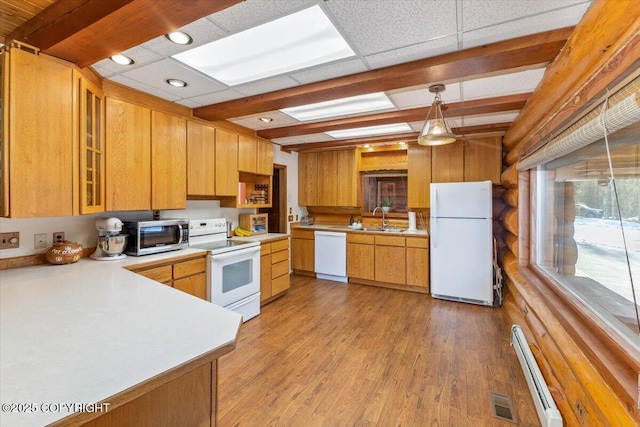 kitchen featuring light countertops, baseboard heating, a sink, light wood-type flooring, and white appliances