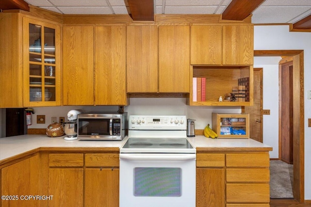 kitchen with electric range, stainless steel microwave, light countertops, and a drop ceiling