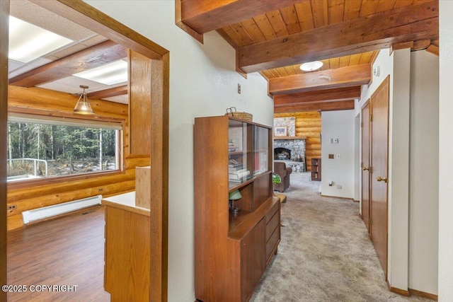 hallway featuring a baseboard radiator, carpet floors, wood ceiling, beam ceiling, and rustic walls