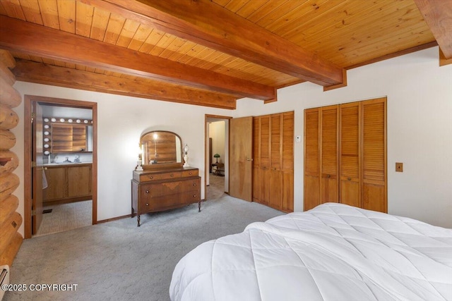 bedroom with connected bathroom, carpet flooring, wood ceiling, beam ceiling, and two closets