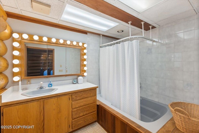 full bath with tile walls, tile patterned flooring, shower / tub combo with curtain, and vanity