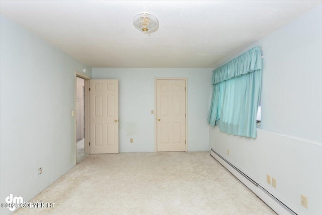 unfurnished bedroom featuring a baseboard heating unit and carpet flooring