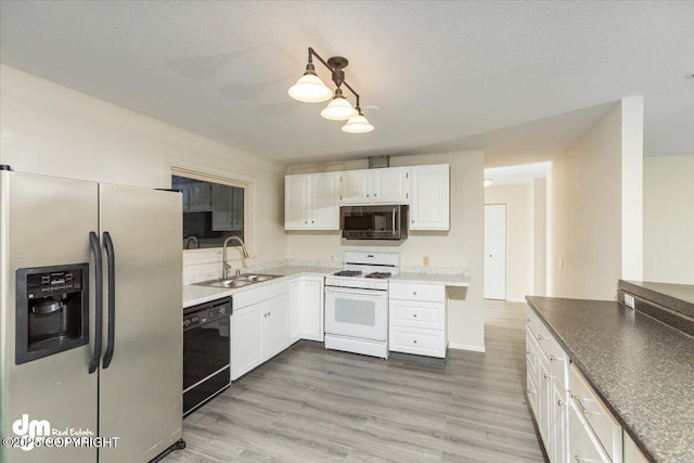 kitchen featuring stainless steel fridge, dishwasher, a sink, white cabinetry, and gas range gas stove