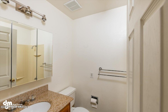 bathroom with toilet, visible vents, and vanity