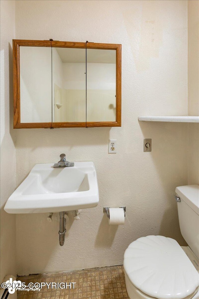 half bathroom featuring a sink and toilet