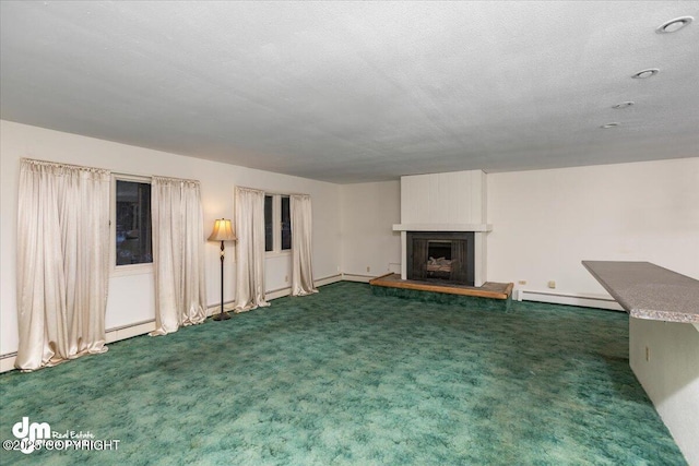 unfurnished living room with a fireplace with raised hearth, a textured ceiling, a baseboard radiator, carpet floors, and baseboard heating