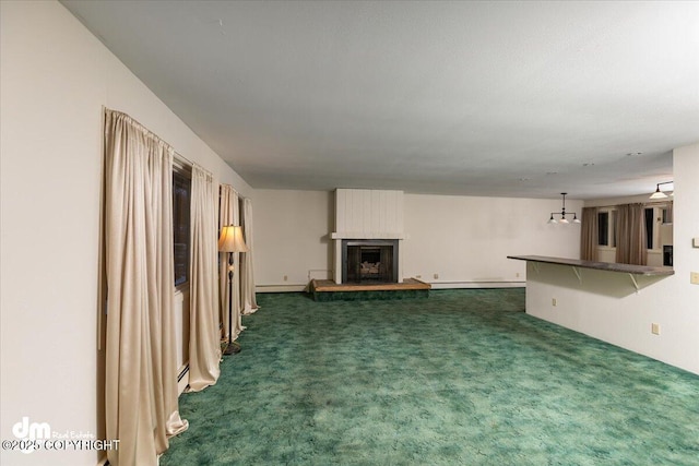 unfurnished living room with dark carpet, a fireplace, and a baseboard radiator